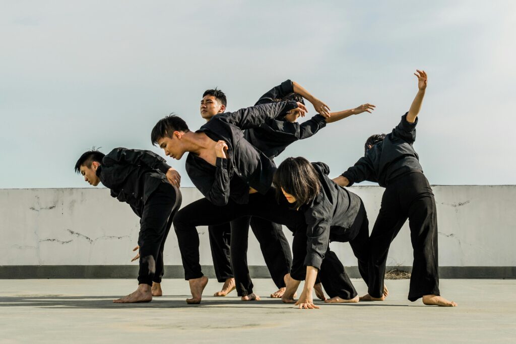 A group of adults performing dynamic contemporary dance on a rooftop.